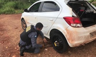 Policial ajuda mulheres trocando pneu furado de um veículo parado no acostamento na MT-175